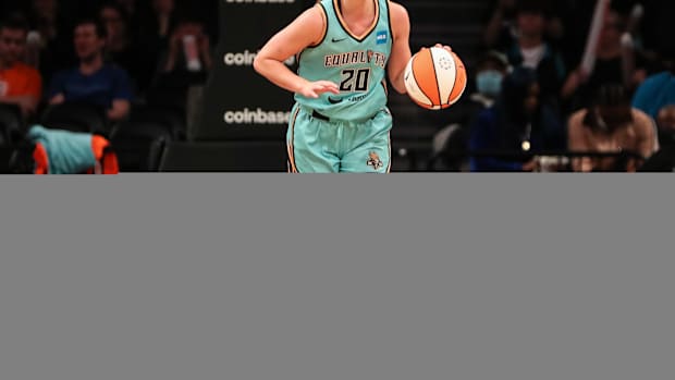 Sabrina Ionescu dribbles the ball.